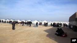 In this photo provided by Turkey's Islamic aid group of IHH, Syrians fleeing conflict in their country's Azaz region, are seen at a temporary accommodation center set up by the group near the Bab al-Salam border crossing, Syria, Feb. 5, 2016.