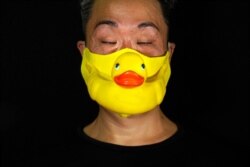 Edmond Kok, a Hong Kong theater costume designer and actor, wears a rubber duck face mask in Hong Kong, Aug. 6, 2020.