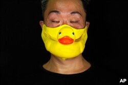Edmond Kok, a Hong Kong theater costume designer and actor, wears a rubber duck face mask in Hong Kong, Aug. 6, 2020.