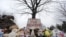 Stuffed animals and a sign calling for prayer rest at the base of a tree near the Newtown Village Cemetery in Newtown, Conn., Dec. 17, 2012. 