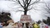 Stuffed animals and a sign calling for prayer rest at the base of a tree near the Newtown Village Cemetery in Newtown, Conn., Dec. 17, 2012. 