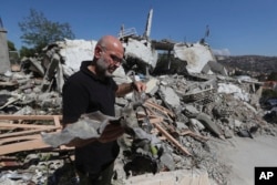 A man shows the remains of an Israeli warplane missile that hit a house and killed a Hezbollah fighter with two of his civilian family members, in Bint Jbeil, Lebanon, on July 16, 2024.