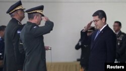 Honduran President Juan Orlando Hernandez salutes military officials during an event with the Honduran Armed Forces in Tegucigalpa, Honduras, Dec. 21, 2017.