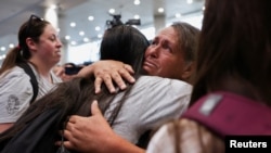 Teresa Araya abraza a su nieta, hija de Jada Thiemann de San José, una de las víctimas de adopciones forzadas de la era de Pinochet, en el aeropuerto de Santiago de Chile el 22 de febrero de 2025