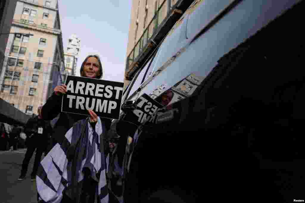 Un manifestante sostiene una pancarta donde se lee &quot;Arresten a Trump&quot;, en inglés, en las inmediaciones del Tribunal Penal del distrito de Manhattan, Nueva York, donde se decide si presentar cargos contra el expresidente en un caso sobre pagos ilegales durante la campaña presidencial de 2016, el 22 de marzo de 2023.