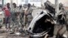 Officers stand by the remains of a wrecked car at the scene of car bomb explosion along the "Kilometre 4" road junction, south of the capital Mogadishu, Somalia, May 5, 2013.