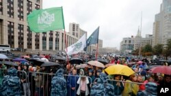 People with national flags and various political parties flags gather during a protest in Moscow, Russia, Saturday, Aug. 10, 2019. 