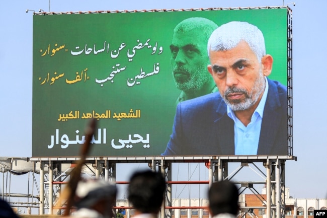 Sebuah papan reklame yang menggambarkan pemimpin Hamas yang terbunuh, Yahya Sinwar, dengan slogan berbahasa Arab "jika Sinwar meninggalkan medan perang, Palestina akan melahirkan seribu Sinwar", 18 Oktober 2024. (Foto: AFP)