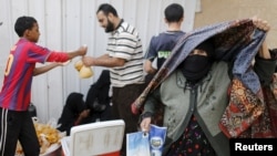 An elderly woman leaves a charity food assistance center after receiving her ration in Yemen's capital Sanaa, July 1, 2015. 