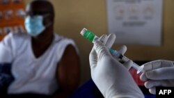 FILE - A health worker prepares a dose of the Oxford/AstraZeneca COVID-19 vaccine in Francistown, Botswana, March 26, 2021. 