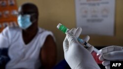 FILE - A health worker prepares a dose of the Oxford/AstraZeneca COVID-19 vaccine in Francistown, Botswana, March 26, 2021. 