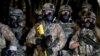 Police stand as protesters gather during a demonstration, July 16, 2020 in Portland, Ore. Federal officers deployed tear gas and fired less-lethal rounds into a crowd of protesters late Thursday. 