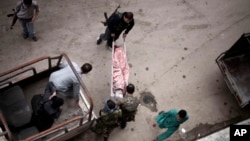 FILE - In this Oct. 11, 2012, file photo, Free Syrian Army fighters take a wounded Syrian woman to a hospital in Aleppo, Syria.