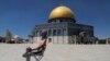 Seorang demonstran Palestina mengenakan masker, memegang batu saat berlangsungnya bentrokan dengan pasukan keamanan Israel di kompleks Masjid Al Aqsa di Kota Tua Yerusalem, Jumat, 18 Juni 2021. (AP Photo/Mahmoud Illean)