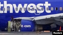 Emergency personnel in Philadelphia monitor the damaged engine of Southwest Airlines Flight 1380, which diverted to the Philadelphia International Airport April 17, 2018, after the airline crew reported damage to one of the aircraft's engines. 
