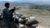 FILE - An Afghan security force member stands at a checkpoint, set alight by Islamic State fighters during overnight clashes, in the Achin district of eastern Nangarhar province, Sept. 28, 2015.