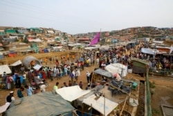 FILE - Rohingya refugees gather at a market inside a refugee camp in Cox's Bazar, Bangladesh, March 7, 2019.