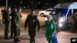 FILE - Ruth Munder walks with an Israeli soldier shortly after her release on November 24, 2023.