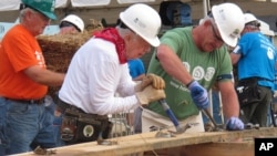 Mantan presiden AS Jimmy Carter (tengah), bekerja dalam proyek konstruksi lembaga Habitat for Humanity di Memphis, Tennessee (22/8). (AP/Adrian Sainz)