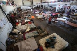 FILE - African and Haitian migrants intending to seek asylum in the U.S. rest on mattresses inside a shelter in Mexicali, Mexico, Oct. 5, 2016.