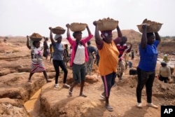 FILE— Women work at an Illegal tin mining site in Jos, Nigeria, April 3, 2024.