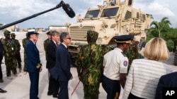 Commander Godfrey Otunge of the Multinational Security Support Mission, third from right, shows U.S. Secretary of State Antony Blinken, fourth from right, vehicles from the U.S. government in Port-au-Prince, Haiti, Sept. 5, 2024. (Roberto Schmidt/Pool photo via AP)