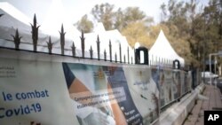 Banners are displayed outside a bivouac where clinical trials for covid-19 vaccines are conducted, in Rabat, Morocco, Dec. 7, 2020.