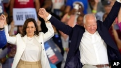 La candidata presidencial demócrata, la vicepresidenta Kamala Harris, y su compañero de fórmula, el gobernador de Minnesota, Tim Walz, se dan las manos en un mitin de campaña el miércoles 7 de agosto de 2024 en Romulus, Michigan, EEUU.