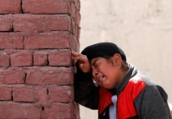An Afghan Sikh boy mourns the victims who were killed during an attack at Sikh religious complex during a funeral in Kabul, Afghanistan, March 26, 2020.