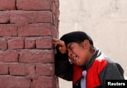 An Afghan Sikh boy mourns the victims who were killed during an attack at Sikh religious complex during a funeral in Kabul, Afghanistan, March 26, 2020.