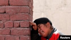 Seorang anak laki-laki Sikh Afghanistan berduka atas para korban yang tewas dalam serangan di kompleks keagamaan Sikh saat pemakaman di Kabul, Afghanistan, 26 Maret 2020. (Foto: Reuters)