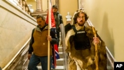 Supporters of President Donald Trump walk down the stairs outside the Senate Chamber as violence erupted at the Capitol following a breach of security, Jan. 6, 2021, in Washington.