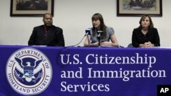 En esta foto del 27 de julio de 2011, aparecen el director para el distrito de Filadelfia del Servicio de Ciudadanía e Inmigración de Estados Unidos (USCIS), Tony Bryson (izquierda), junto a la oficial de adjudicaciones, Rosemary Hartmann, con el oficial 