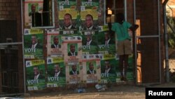 FILE - A boy plays next to election posters in Bulawayo, Zimbabwe, June 23, 2018. The U.S. said Monday it cut funding to some civil action groups in the country fearing that the money could be misused ahead of July 30 elections. 