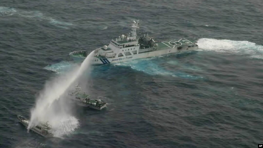 In this photo released by Japan Coast Guard 11th Regional Headquarters, a Japanese Coast Guard patrol boat uses water cannon to warn a Taiwanese leisure boat, left, and a Taiwanese Coast Guard boat off Uotsuri in Japanese and Diaoyu Dao in Chinese, January 24, 2013.