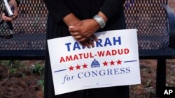 Attorney Tahirah Amatul-Wadud, who is challenging incumbent U.S. Rep. Richard Neal, D-Mass., holds a campaign sign as she meets residents of an apartment complex in Springfield, Massachusetts, June 18, 2018. 