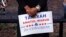 Attorney Tahirah Amatul-Wadud, who is challenging incumbent U.S. Rep. Richard Neal, D-Mass., holds a campaign sign as she meets residents of an apartment complex in Springfield, Massachusetts, June 18, 2018. 