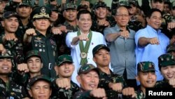 \Philippines President Rodrigo Duterte (C) clenches fist with members of the Philippine Army during his visit at the army headquarters in Taguig city, metro Manila, Philippines October 4, 2016. REUTERS/Romeo Ranoco