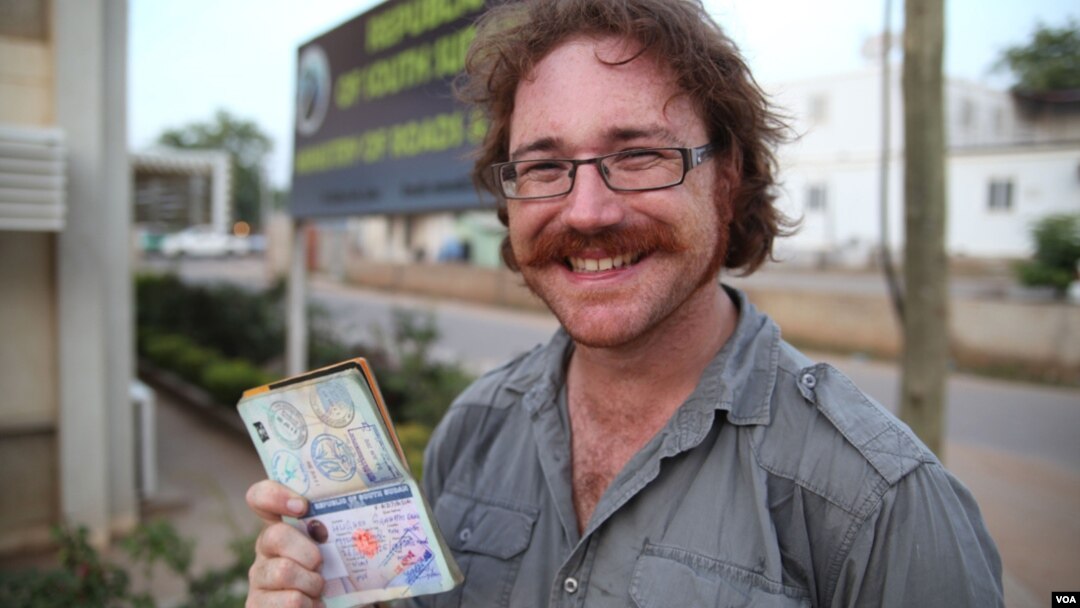 Graham Hughes brandishing his latest visa outside South Sudan's Ministry of Roads in Juba. The 33-year-old broke a world record when he reached South Sudan, the last on his list of 201 sovereign states to visit without flying.
