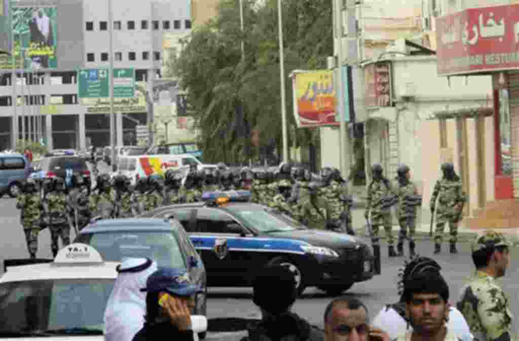 Saudi riot police gather as Saudi Shi'ite protesters, unseen, chant slogans during a demonstration in Qatif, March 11, 2011