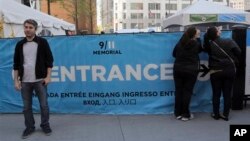 Seorang pengunjung Tugu Peringatan 11 September di New York, berpose di depan pintu masuk museum (4/5). Pengelola Museum 11 September di World Trade Center New York menetapkan HTM sebesar $20-$25, dan menurut rencana akan dibuka musim semi 2014.