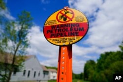 A warning sign is posted along the path of the Colonial Pipeline in Garnet Valley, Pa., May 10, 2021.