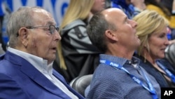 FILE - Orlando Magic owner Rich DeVos (L), his son, Amway president Doug DeVos (C), and daughter-in-law, Maria DeVos, watch from their court side seats during the first half of an NBA basketball game against the Houston Rockets Jan. 3, 2018, in Orlando, FLA.