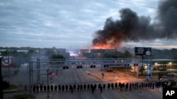 Law enforcement officers amassed along Lake Street near Hiawatha Ave. as fires burned after a night of unrest and protests in the death of George Floyd early May 29, 2020 in Minneapolis. 