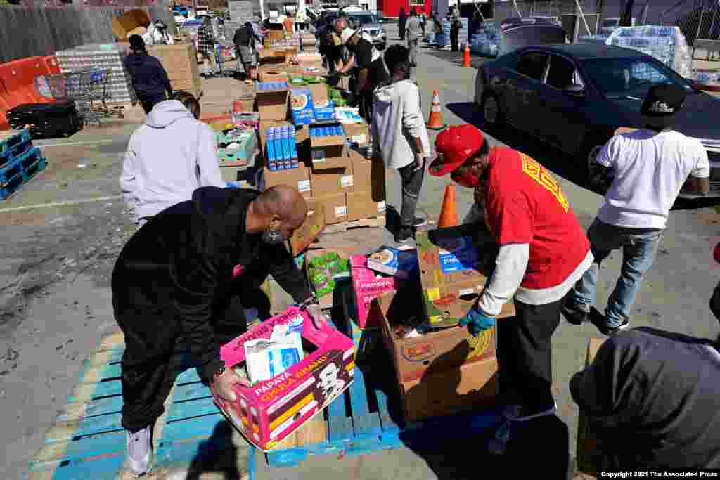 Volunteers load vehicles with food and water at a distribution site in Houston, Texas. The city&#39;s boil water notice has been rescinded, however, many residents lack water at home due to broken pipes.&#160;