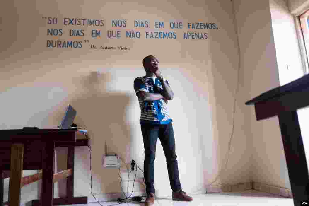 Edson Incobte, who works at a local development organization, says Kriol is the only language that is able to truly communicate the situation in Guinea-Bissau. Behind him, a quote in Portuguese reads: "We only exist on days when we do. On the days when we don't do, we simply endure." Bissau, Guinea-Bissau, Dec. 18, 2017. (R. Shyrock/VOA)&nbsp;