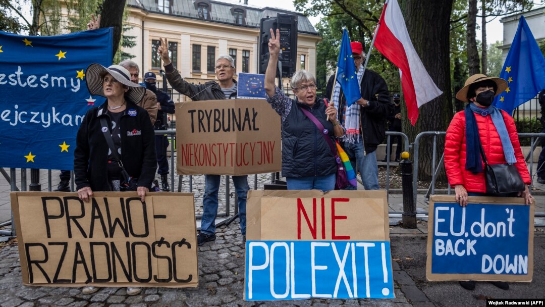 Demonstran memegang spanduk bertuliskan (dari kiri) "Rule of Law", "Inconstitutional Court", "No to Polexit" dan "EU Don't Back Down" saat mereka melakukan protes pada 31 Agustus 2021 di depan Mahkamah Konstitusi di Warsawa. (Foto: AFP/Wojtek Radwanski)