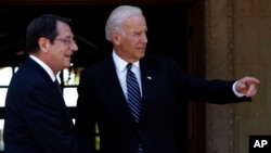 US Vice President Joe Biden (R) points as Cypriot President Nicos Anastasiades smiles before their meeting in the Cypriot capital Nicosia on May 22, 2014.