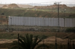 FILE - A picture taken in Rafah in the southern Gaza Strip at the border with Egypt shows a concrete wall under construction on the Egyptian side of the border, Feb. 19, 2020.