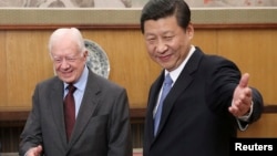 FILE - Then-leader of China's Communist Party of China Xi Jinping, right, gestures to former U.S. President Jimmy Carter during their meeting at the Zhongnanhai, the central government compound in Beijing, China, Dec. 13, 2012. (China Daily via Reuters)